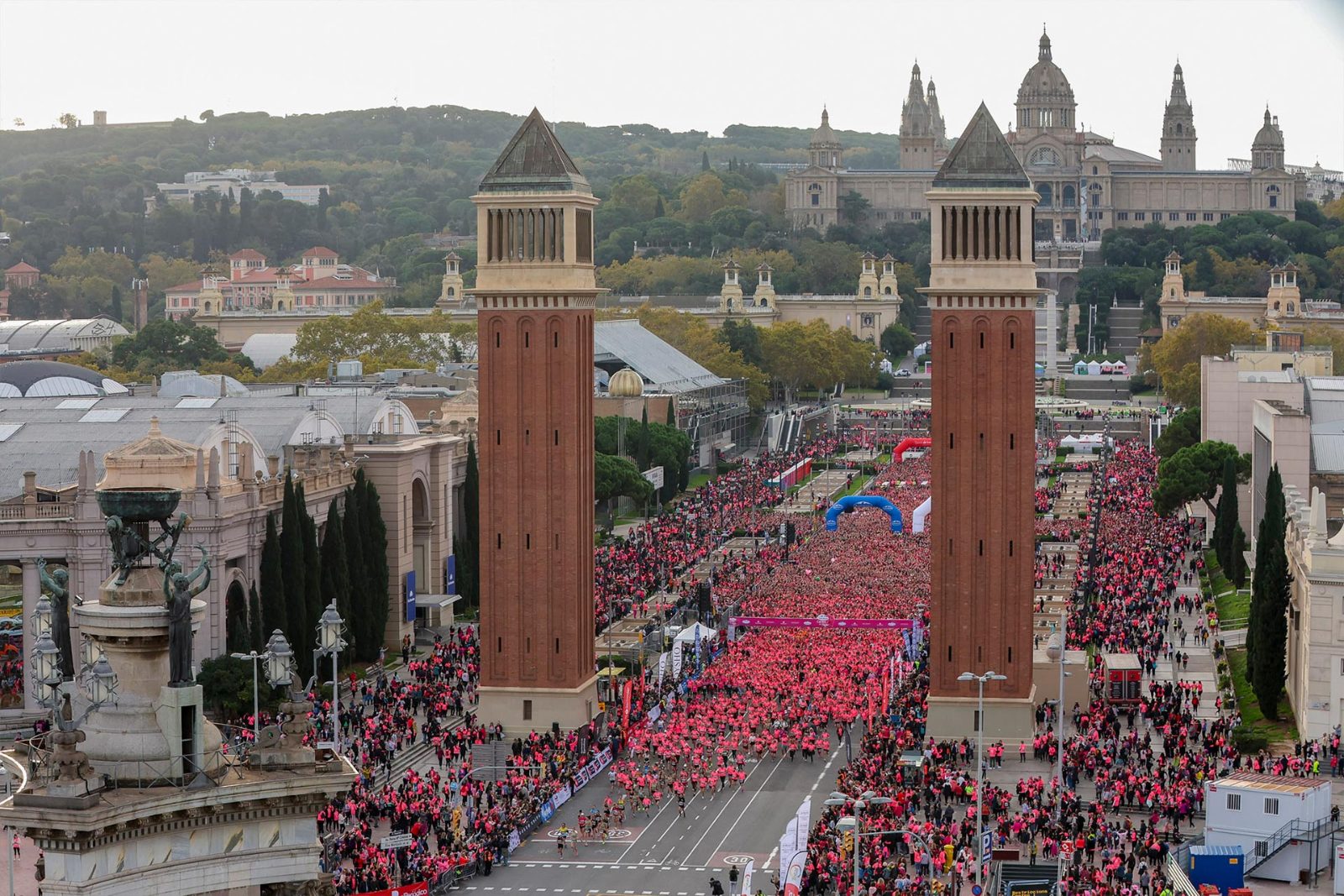 Miles de corredoras en la salida de la Carrera de la Mujer de Barcelona junto a las torres venecianas