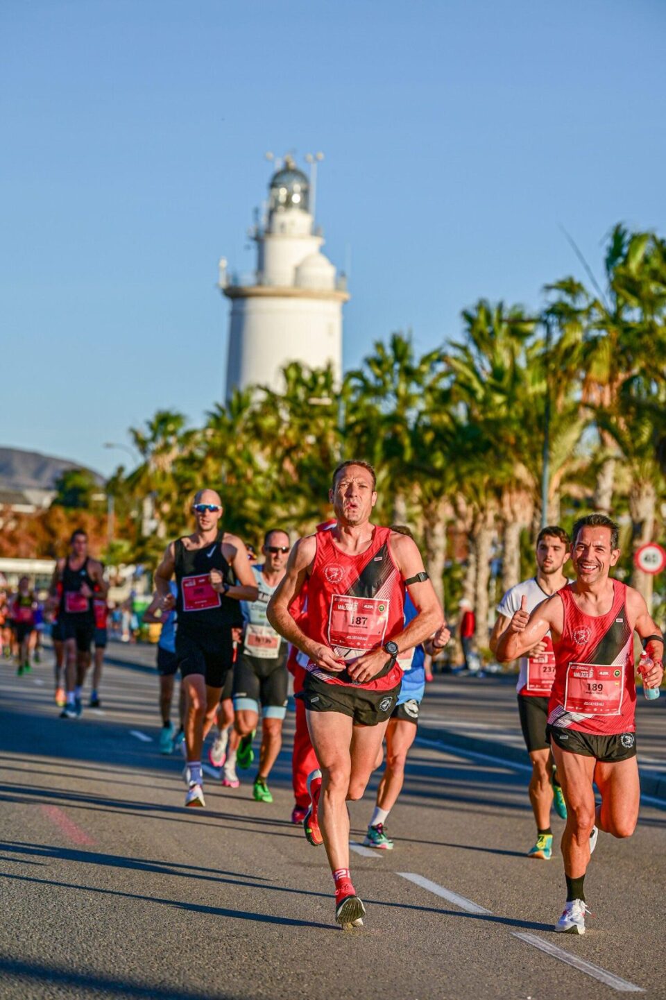 Corredores del Maratón de Málaga pasando junto a La Farola
